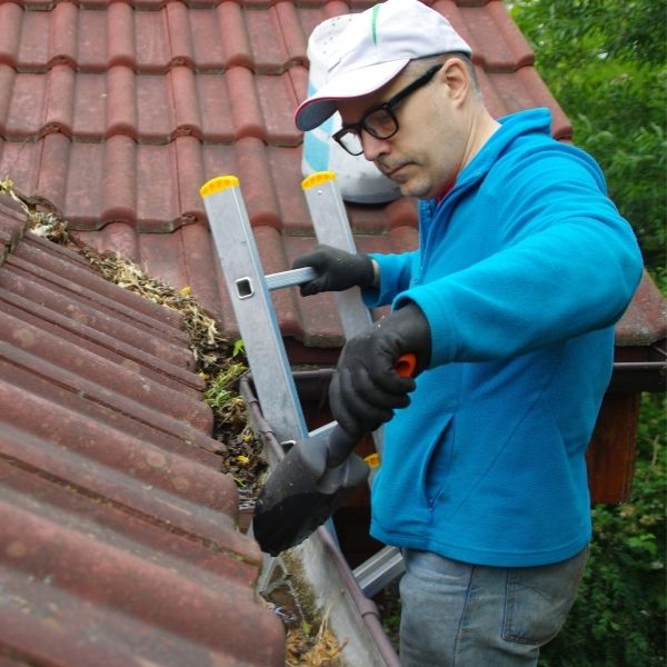 Roofing Guys Melbourne gutter cleaning service removing leaves and debris from residential roof gutter